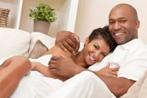 couple with beautiful smiles cuddling in bed